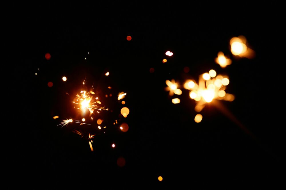 Bright and dazzling sparks creating a warm bokeh effect against a black background