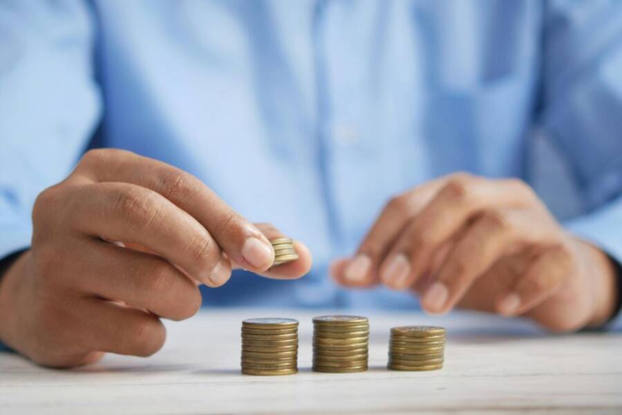 Close-up of hands stacking gold coins, symbolizing financial growth and savings