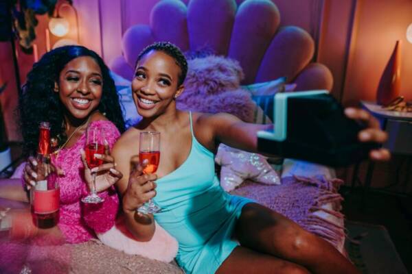 藍綠色意粉錶帶禮服拿著清晰的水杯的女人