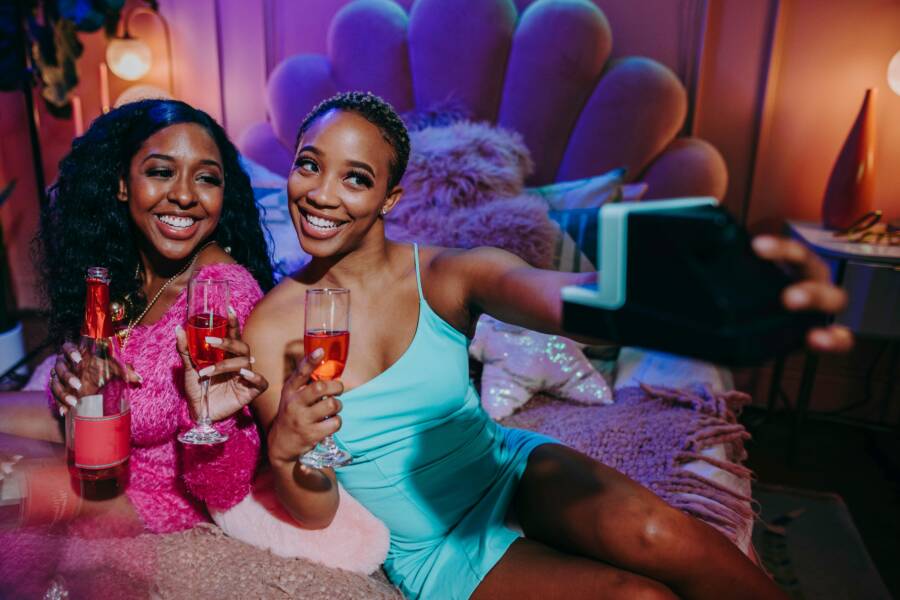 藍綠色意粉錶帶禮服拿著清晰的水杯的女人