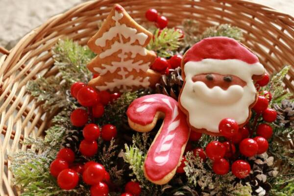 一個溫馨的節日籃子，裡面裝著聖誕老人、拐杖糖、聖誕樹餅乾以及其他冬季裝飾。