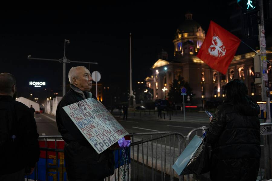 夜間聚集在市區的擁擠者，揮舞著旗幟，舉著標語。