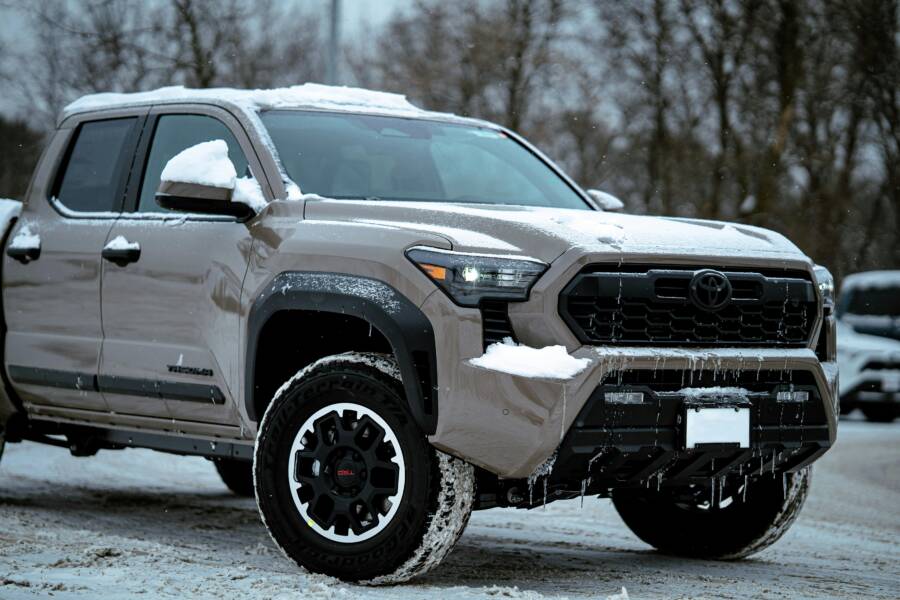 一輛堅固耐用的越野卡車在冬天停在積雪覆蓋的地面上。