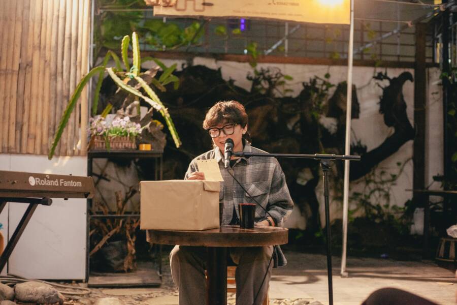 一位年輕藝術家在國外用麥克風朗誦詩歌。