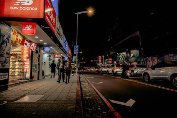 台北充滿活力的夜間街道，以商店和交通為特色。