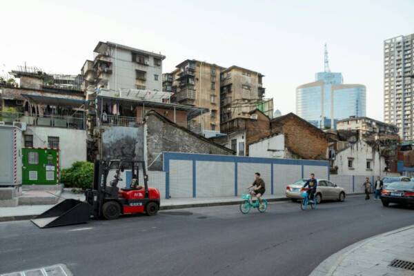 繁華的都市街道上，現代摩天大樓與舊建築形成鮮明對比。