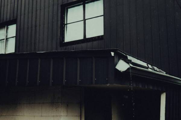 雨天拍攝的建築物外景，以暗色調為主，呈現戲劇性。