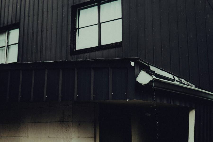 雨天拍攝的建築物外景，以暗色調為主，呈現戲劇性。