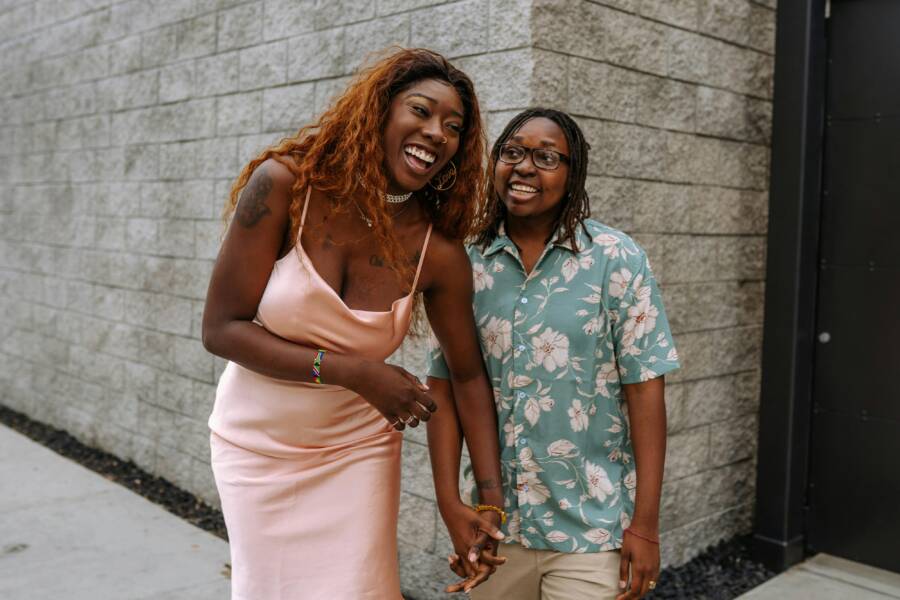 2名婦女站在磚牆旁邊