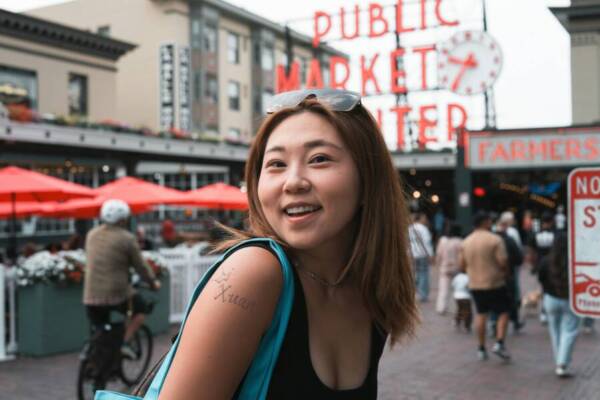 西雅圖派克市場（Pike Place Market）的微笑女士，背景是標誌性的市場標誌。