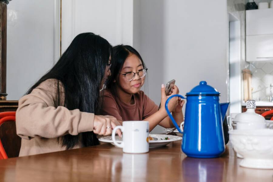 坐在棕色的木桌旁邊的棕色毛衣的女人