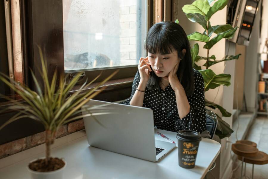 黑色和白色的長袖襯衫，坐在餐桌旁邊和 macbook 的女人