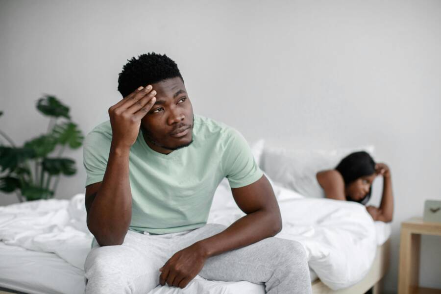 如何在親密關係中不再迷失自我:界線、覺察與實用練習 Troubled couple experiencing conflict in a bedroom setting, expressing emotional distress.