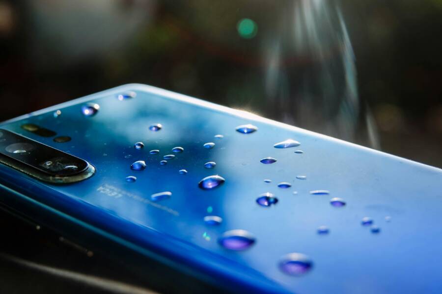 Fixing a Foggy Phone Camera After Water Damage (iPhone and Android) A sleek blue smartphone with water droplets showcasing modern technology and design.