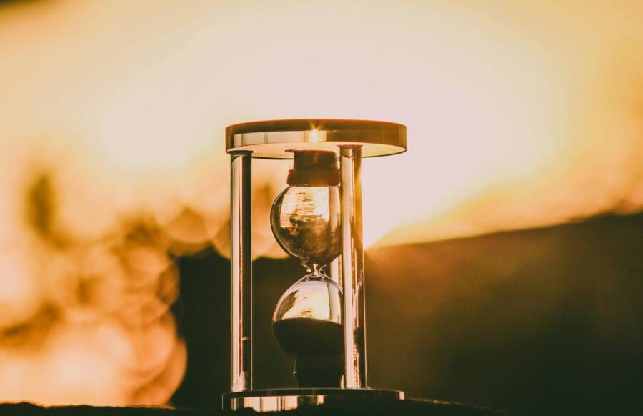 Close-up of an hourglass capturing the essence of time against a sunset backdrop