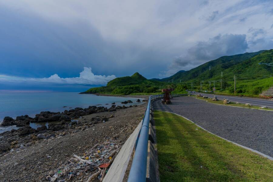 Explore the captivating coastal road with lush green hills and rocky beaches along Taiwan