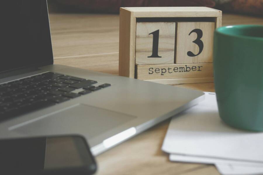 Modern home office setup with a laptop, smartphone, and calendar displaying September 13.