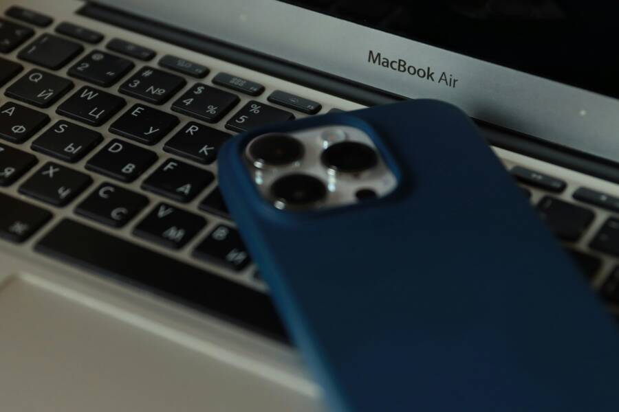A close-up of a MacBook Air and an iPhone, showcasing modern technology in an office setting