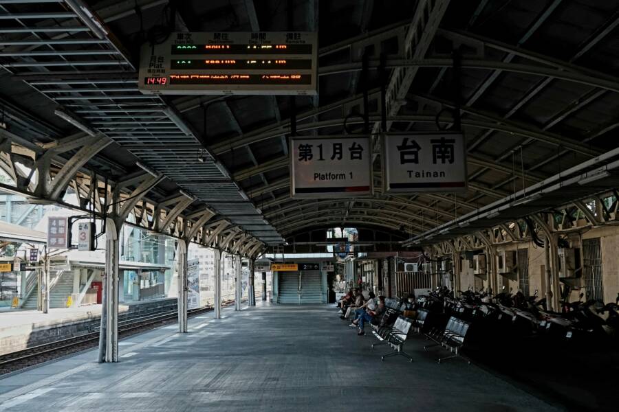 Empty train station platform in Tainan with benches and signs, creating a serene urban scene