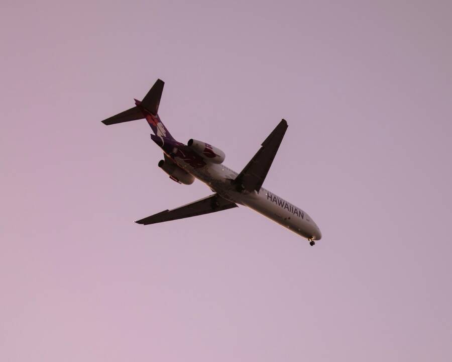 Hawaiian airline plane captured flying against a clear dusk sky in Kailua-Kona, Hawaii.