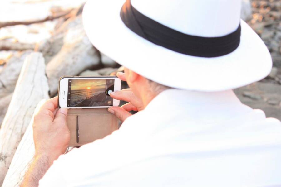 image of a person taking a photo with a smartphone in soft outdoor light