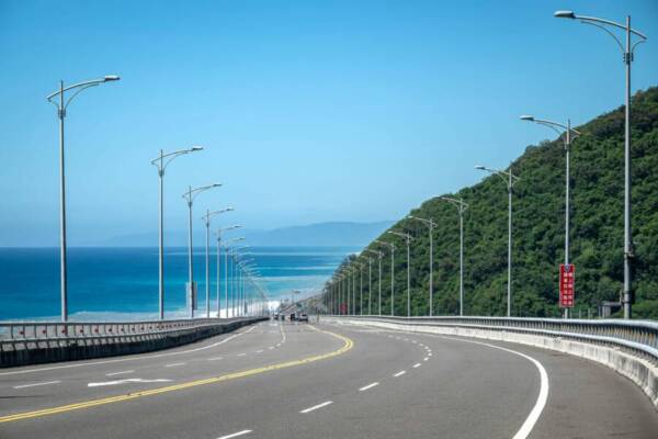 Explore the stunning coastal road in Taitung, Taiwan with lush greenery and ocean views.