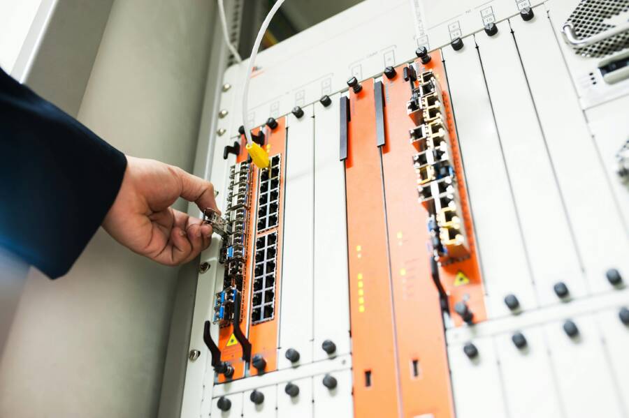 Close-up of a hand adjusting network equipment in a data center
