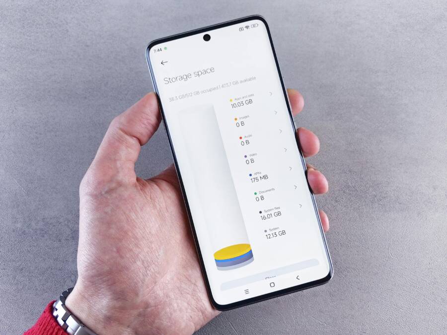 (Hand holding smartphone displaying storage space usage with a clean interface.)