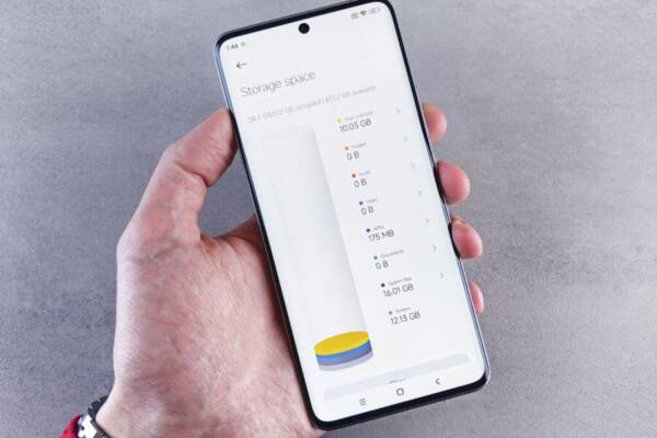 Hand holding smartphone displaying storage space usage with a clean interface.