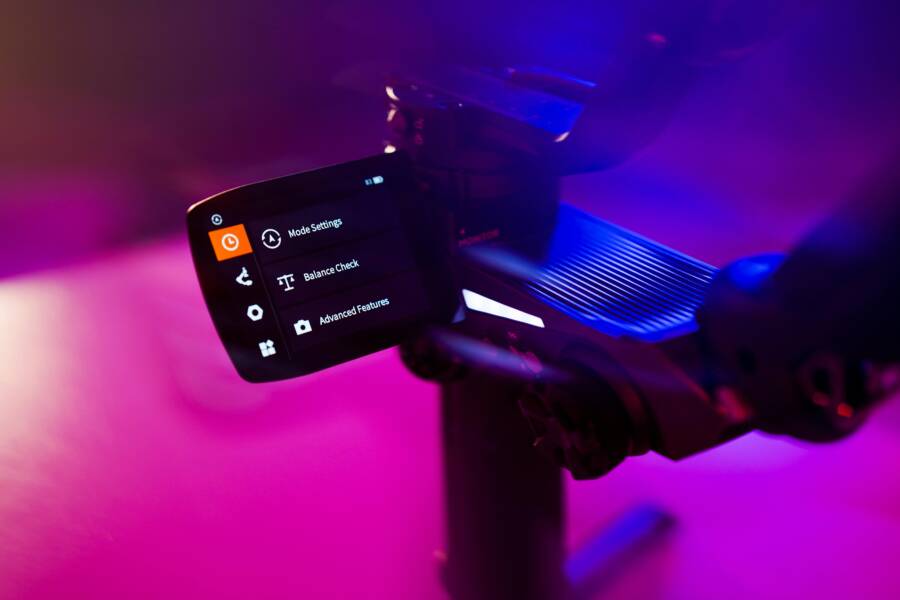 Brightly illuminated electronic device screen displaying settings in a purple-hued studio environment.
