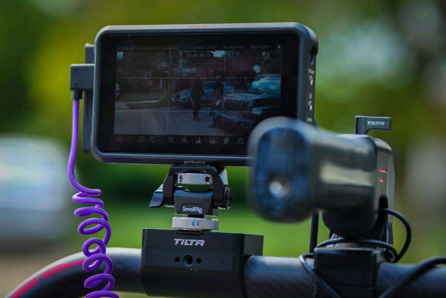 Close-up of a camera rig with monitor in a sunny outdoor setting.