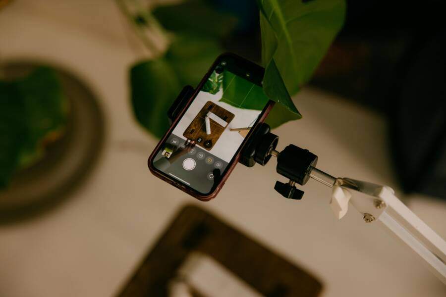 Phone mounted on stand capturing an artistic overhead view with plants.