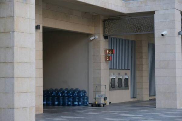 Entrance with stacked water coolers, modern architecture, and restroom signage.