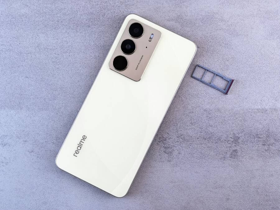 How to Fix a Phone Stuck on Searching for Network (Android and iPhone) Elegant white smartphone on a grey surface next to a SIM card tray, showcasing modern design