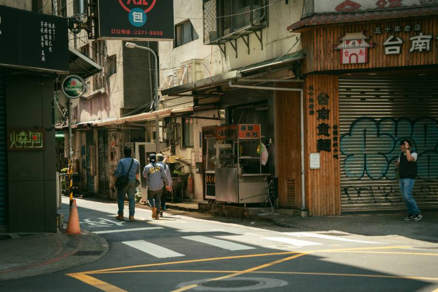 Urban street in Taipei, Taiwan with people walking and traditional shops