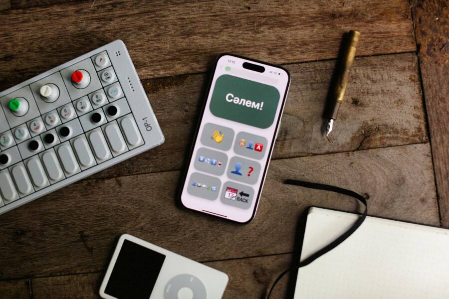 Flat lay of smartphone, MIDI controller, and vintage pen on wooden desk. Ideal for tech and lifestyle themes.