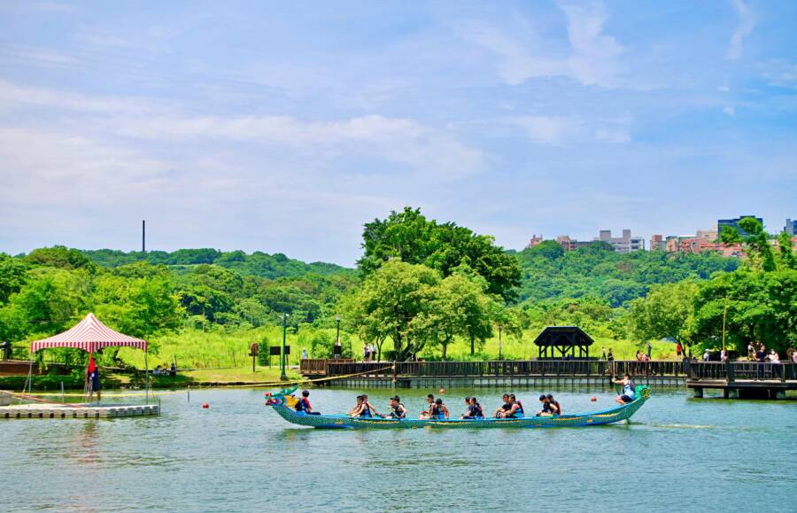 Vibrant dragon boat racing event in lush Taiwan park under a bright blue sky