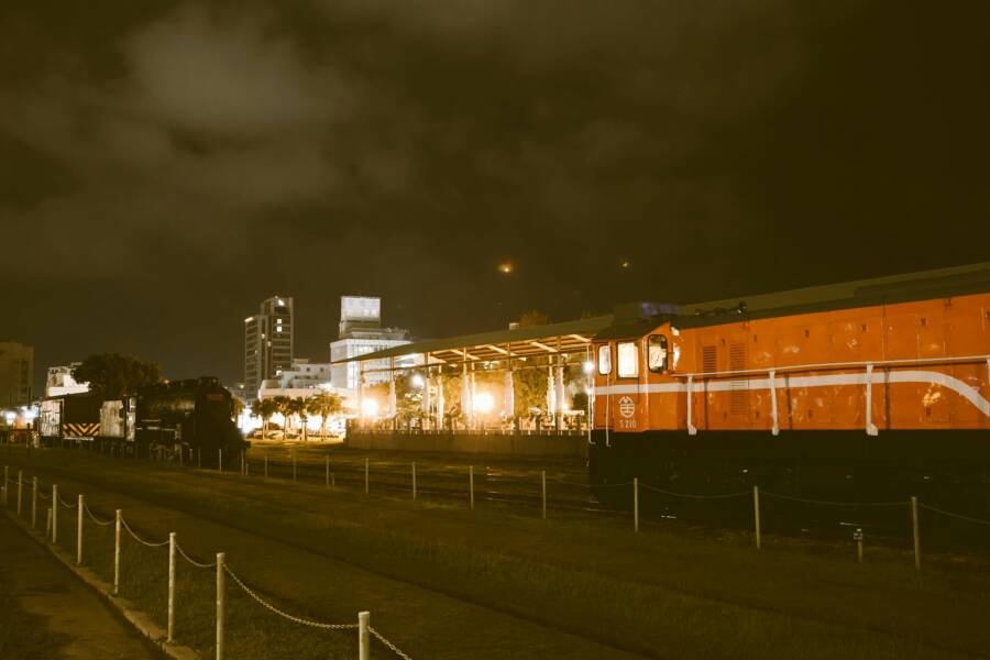 Illuminated train station in Kaohsiung, Taiwan featuring vintage trains at night.