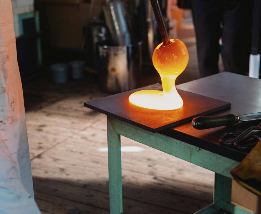 Hot glass being shaped in a workshop in Nagano, Japan. Close-up view of traditional glassblowing process.