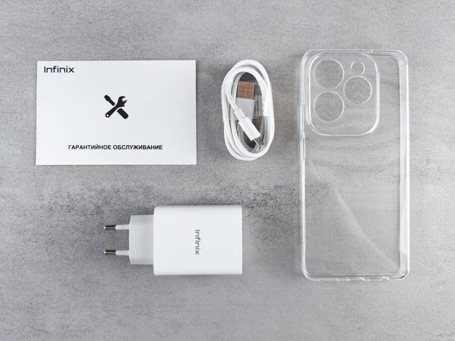 Flat lay of smartphone accessories including charger, cable, case, and warranty card