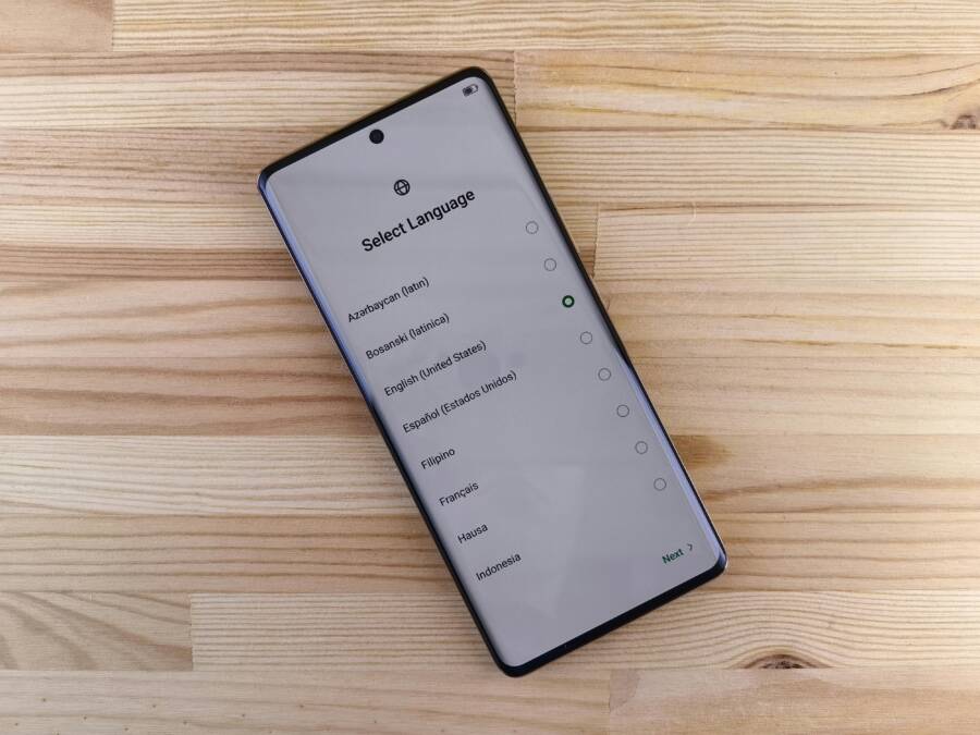 Close-up of smartphone with language selection screen on wooden table