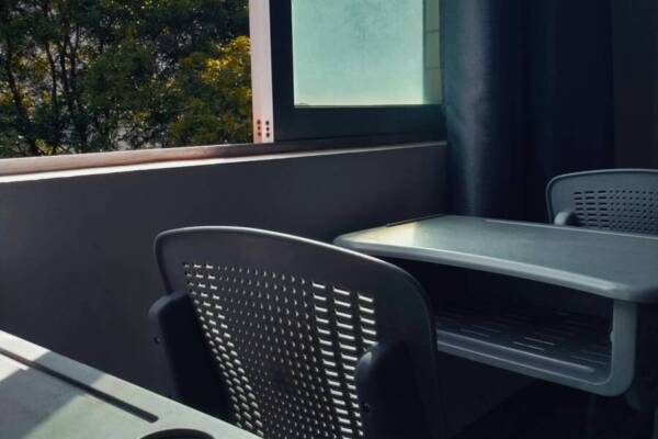 An empty classroom bathed in sunlight through a window