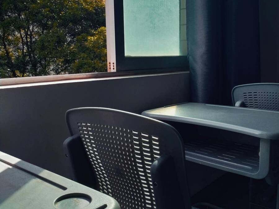 An empty classroom bathed in sunlight through a window