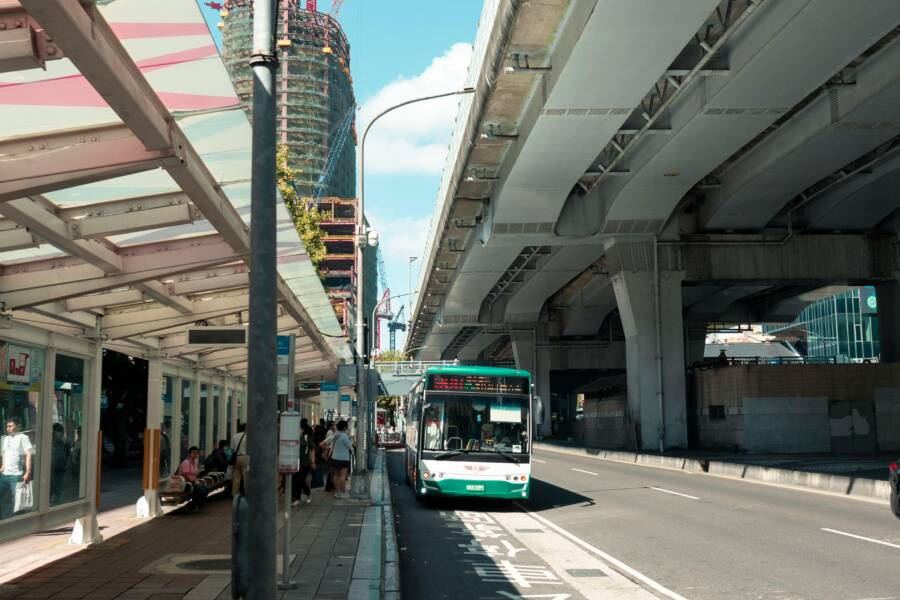 Urban scene capturing a bus under an elevated highway in Taipei City, Taiwan.