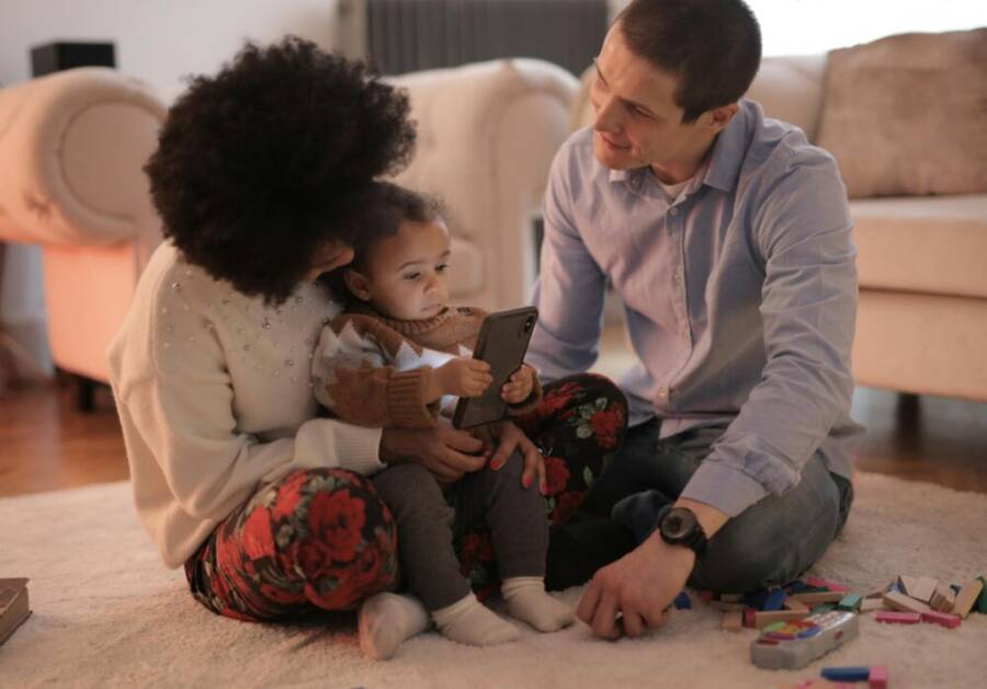 A family planning together with a smartphone in a cozy living room