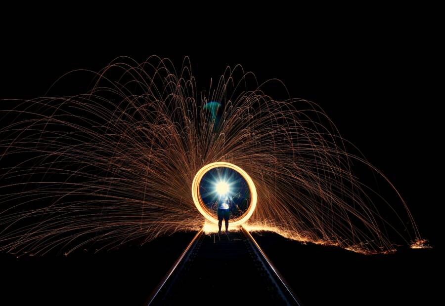 A mesmerizing display of sparks and light along railroad tracks at night, showcasing artistic long exposure photography.