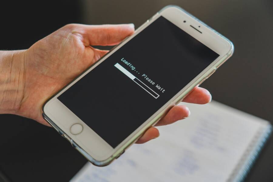 image of a person holding a smartphone with a loading screen