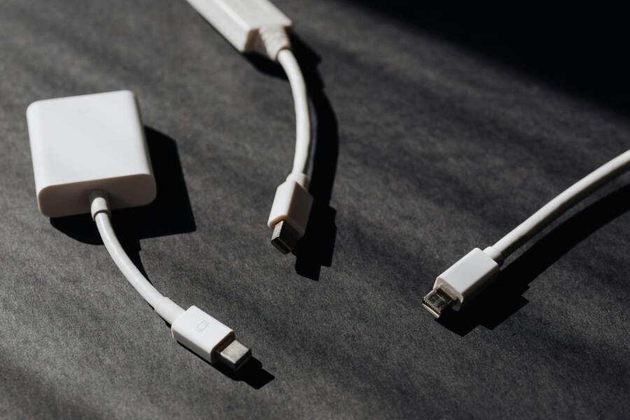 A collection of white USB and adapter cables on a textured dark background