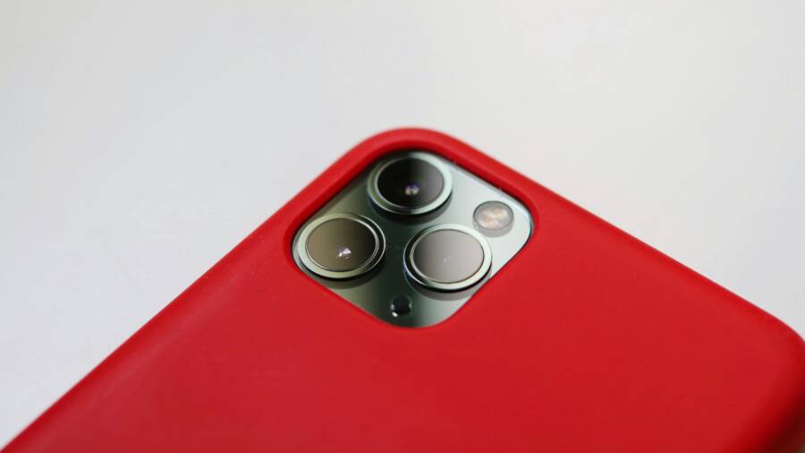 Macro shot of a smartphone camera with a red case, highlighting lens detail