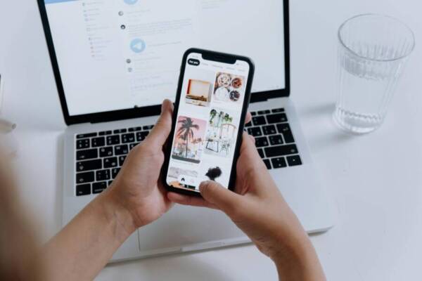 image of a smartphone gallery and laptop in the background